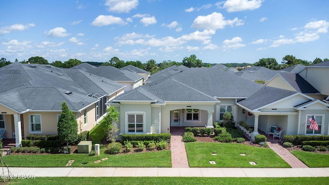 3402 Torre Blvd, New Smyrna Beach, FL 32168 - view of front facade with a front yard, a shingled roof, stucco siding, and a residential view