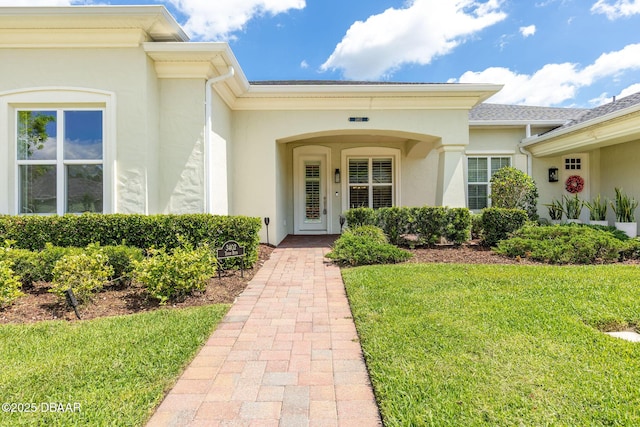 3402 Torre Blvd, New Smyrna Beach, FL 32168 - view of exterior entry featuring stucco siding and a lawn