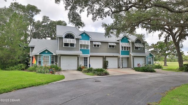 156 Grand Oaks Cir, Daytona Beach, FL 32114 - multi unit property featuring roof with shingles, driveway, a garage, and a front lawn