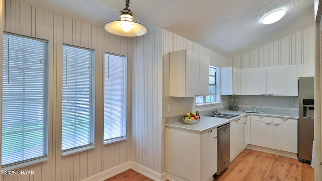 156 Grand Oaks Cir, Daytona Beach, FL 32114 - kitchen featuring a textured ceiling, stainless steel appliances, light wood-style floors, light countertops, and white cabinetry