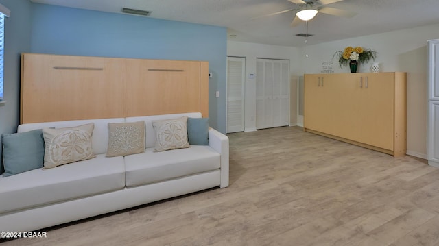 living room featuring ceiling fan and light hardwood / wood-style floors