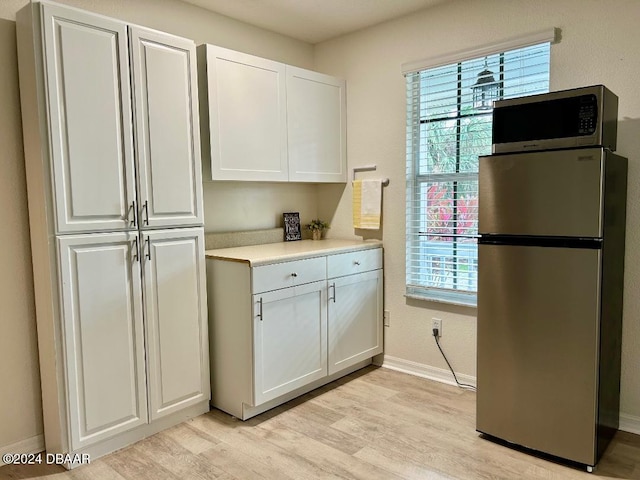 kitchen featuring white cabinets, light hardwood / wood-style floors, and appliances with stainless steel finishes