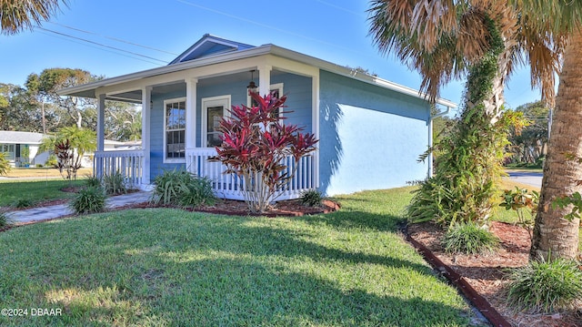 view of property exterior with covered porch and a yard