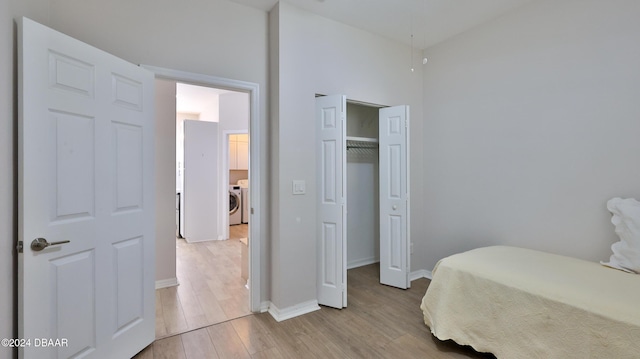 bedroom featuring a closet, washer / clothes dryer, and light hardwood / wood-style flooring