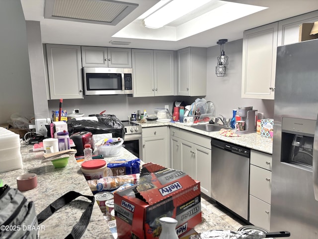 kitchen featuring appliances with stainless steel finishes, gray cabinets, a sink, and visible vents