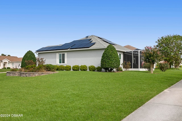 view of side of property featuring a lanai, solar panels, and a yard