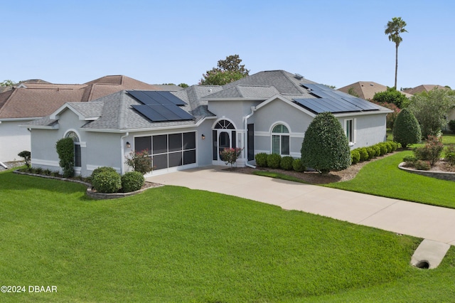 view of front of home with solar panels and a front lawn