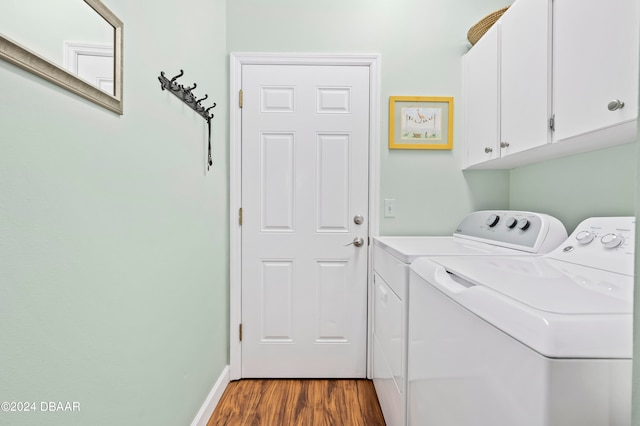 laundry room with washer and clothes dryer, dark hardwood / wood-style flooring, and cabinets