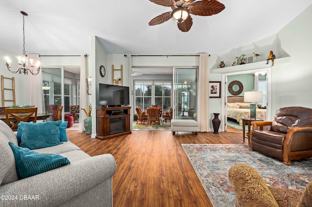 living room with ceiling fan with notable chandelier and hardwood / wood-style flooring