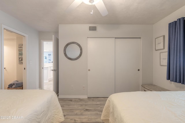 bedroom with light hardwood / wood-style floors, a closet, and ceiling fan