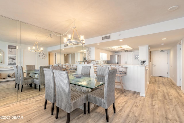 dining room with an inviting chandelier and light wood-type flooring