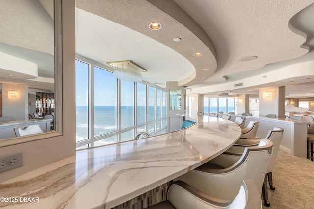 dining room with a water view, a wealth of natural light, and a wall of windows