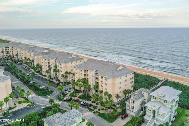 birds eye view of property featuring a water view and a beach view