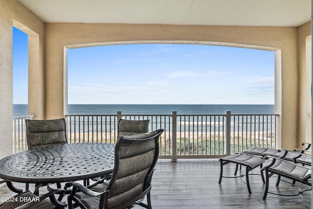 balcony featuring a beach view and a water view