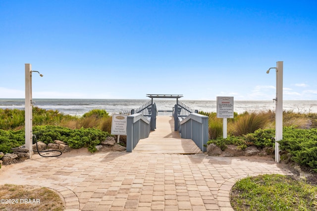 surrounding community featuring a beach view and a water view