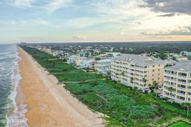 aerial view at dusk with a view of the beach and a water view