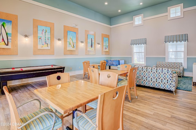 dining space with a towering ceiling and light hardwood / wood-style flooring