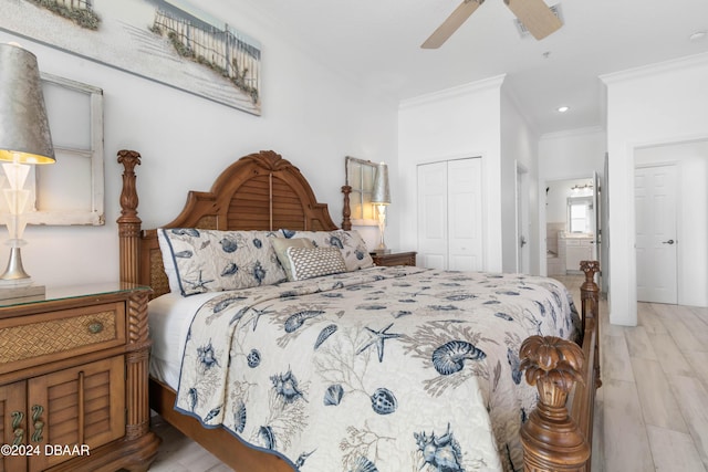 bedroom featuring light wood-type flooring, a closet, ornamental molding, and ceiling fan