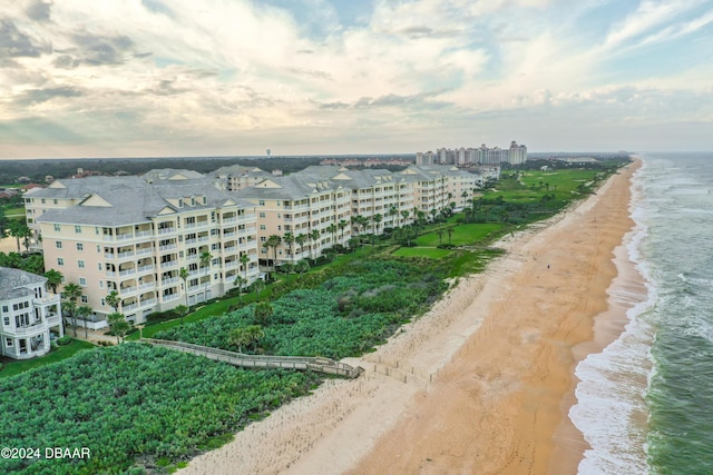 birds eye view of property featuring a water view and a beach view