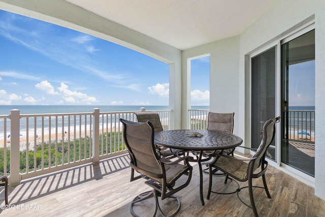 balcony featuring a water view and a view of the beach