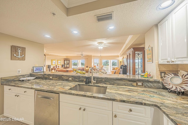 kitchen with sink, a textured ceiling, and white cabinets