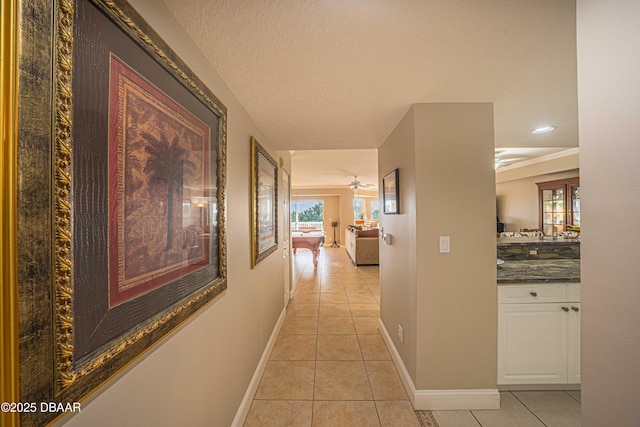 hallway featuring a textured ceiling and light tile patterned floors