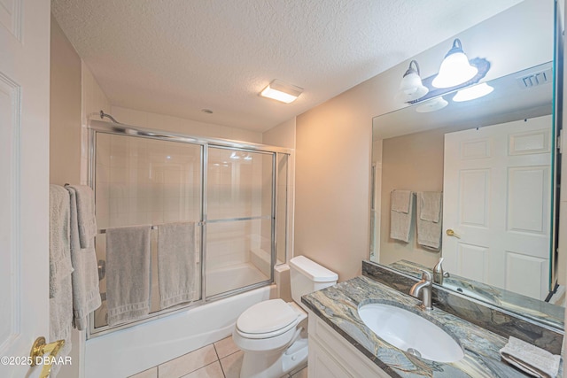 full bathroom with toilet, a textured ceiling, combined bath / shower with glass door, tile patterned floors, and vanity