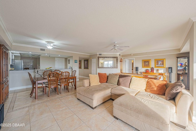 living room with ceiling fan, a textured ceiling, ornamental molding, and light tile patterned flooring