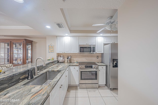 kitchen featuring sink, white cabinets, stainless steel appliances, and light tile patterned flooring