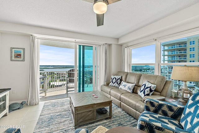 3721 S Atlantic Ave Unit 801, Daytona Beach Shores, FL 32116 - living area featuring ceiling fan, a textured ceiling, tile patterned flooring, and a water view