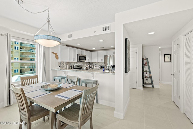 3721 S Atlantic Ave Unit 801, Daytona Beach Shores, FL 32116 - dining area featuring light tile patterned floors, recessed lighting, and a textured ceiling