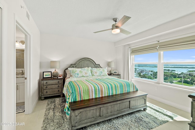 3721 S Atlantic Ave Unit 801, Daytona Beach Shores, FL 32116 - bedroom with light tile patterned floors, a textured ceiling, a ceiling fan, and a water view
