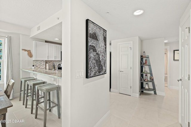 3721 S Atlantic Ave Unit 801, Daytona Beach Shores, FL 32116 - corridor featuring a textured ceiling, light tile patterned floors, and recessed lighting