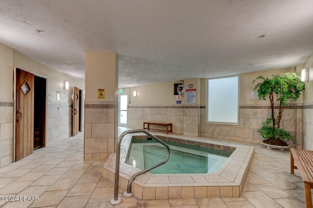 view of swimming pool featuring an indoor hot tub