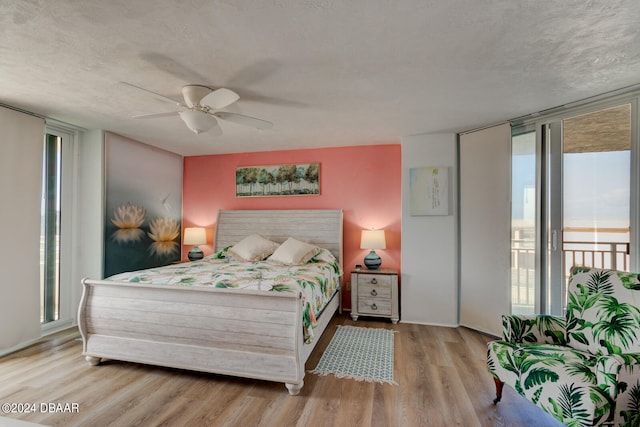 bedroom with floor to ceiling windows, ceiling fan, a textured ceiling, light hardwood / wood-style flooring, and access to outside