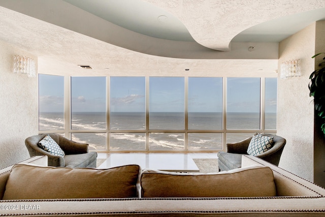 interior space with a healthy amount of sunlight, a water view, and floor to ceiling windows