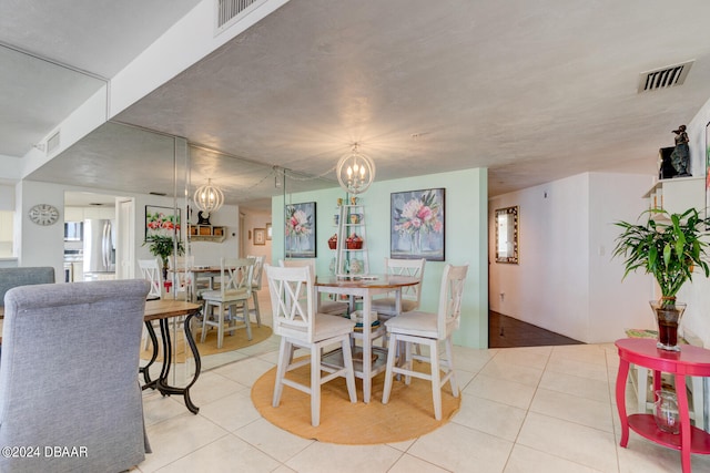 dining area featuring light tile patterned floors and a notable chandelier