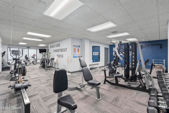 gym with a drop ceiling and carpet