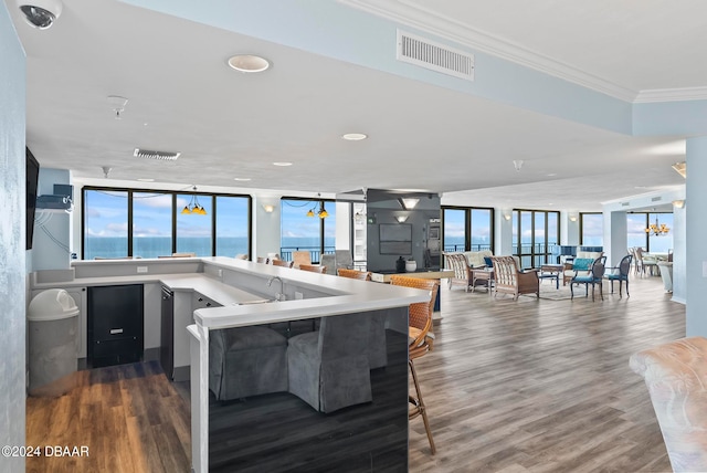 interior space with crown molding, dark hardwood / wood-style flooring, floor to ceiling windows, a water view, and kitchen peninsula