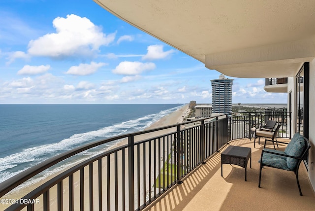 balcony featuring a beach view and a water view