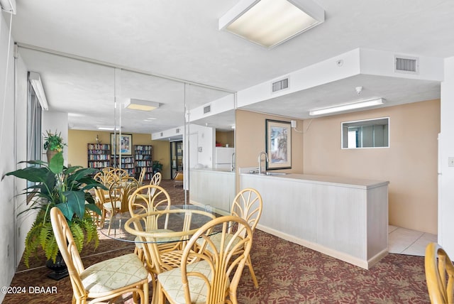 dining space featuring light carpet and sink