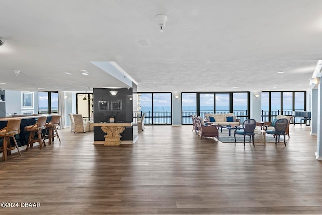 living room with a wall of windows, wood-type flooring, and a water view