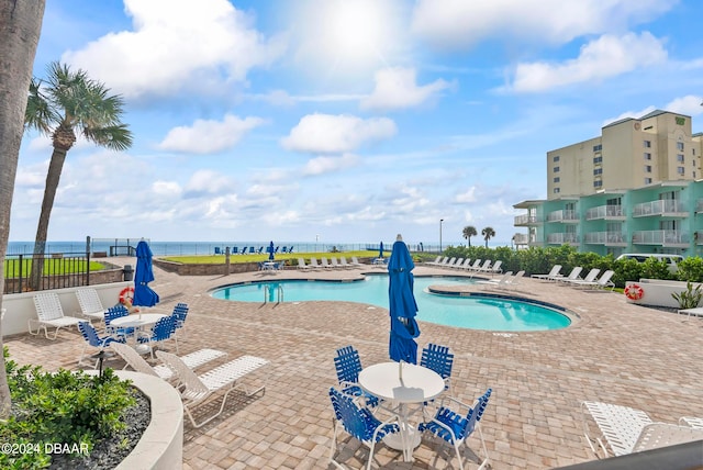 view of pool with a water view and a patio area