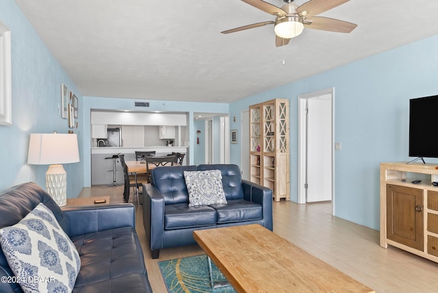 living room featuring light wood-type flooring and ceiling fan