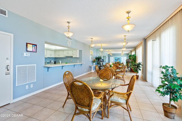 tiled dining space featuring a textured ceiling