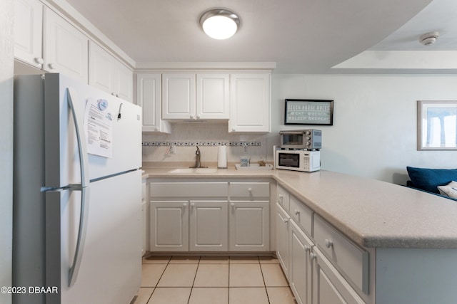 kitchen featuring sink, white appliances, kitchen peninsula, and white cabinets