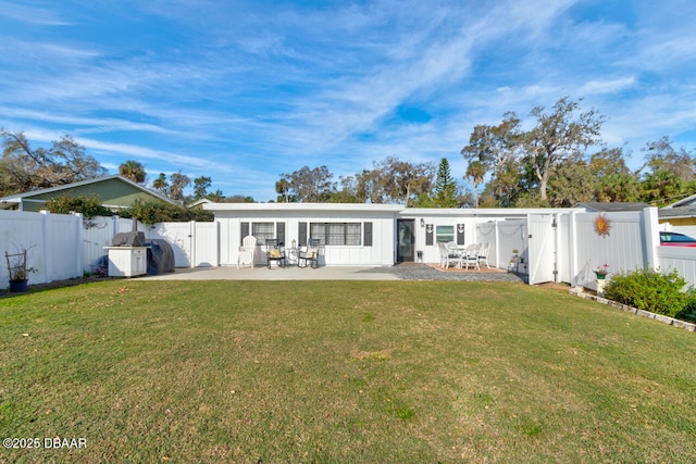 back of house with a patio, a yard, and a fenced backyard