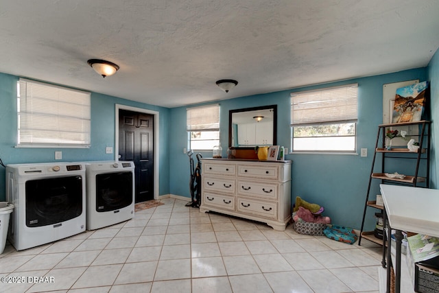 laundry room with light tile patterned floors, a textured ceiling, laundry area, separate washer and dryer, and baseboards