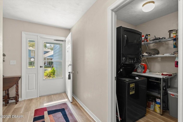 interior space with stacked washer and dryer and light hardwood / wood-style floors