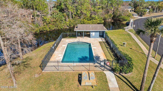 view of pool featuring a patio, a water view, a yard, and an outbuilding